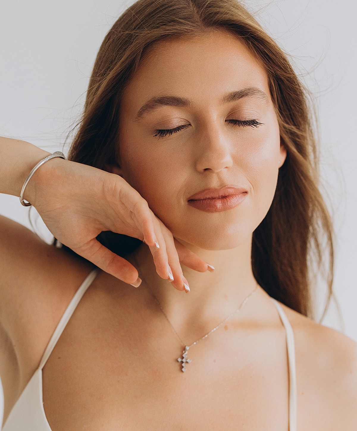 Woman with closed eyes and elegant jewelry.