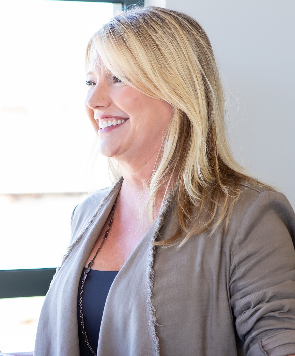 Laser skin rejuvenation model with long blonde hair and jacket.