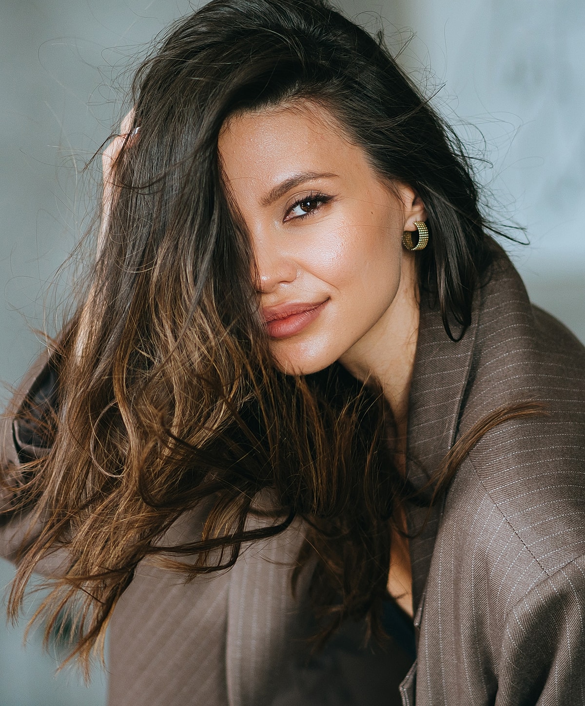 Sculptra model with long hair in stylish outfit.