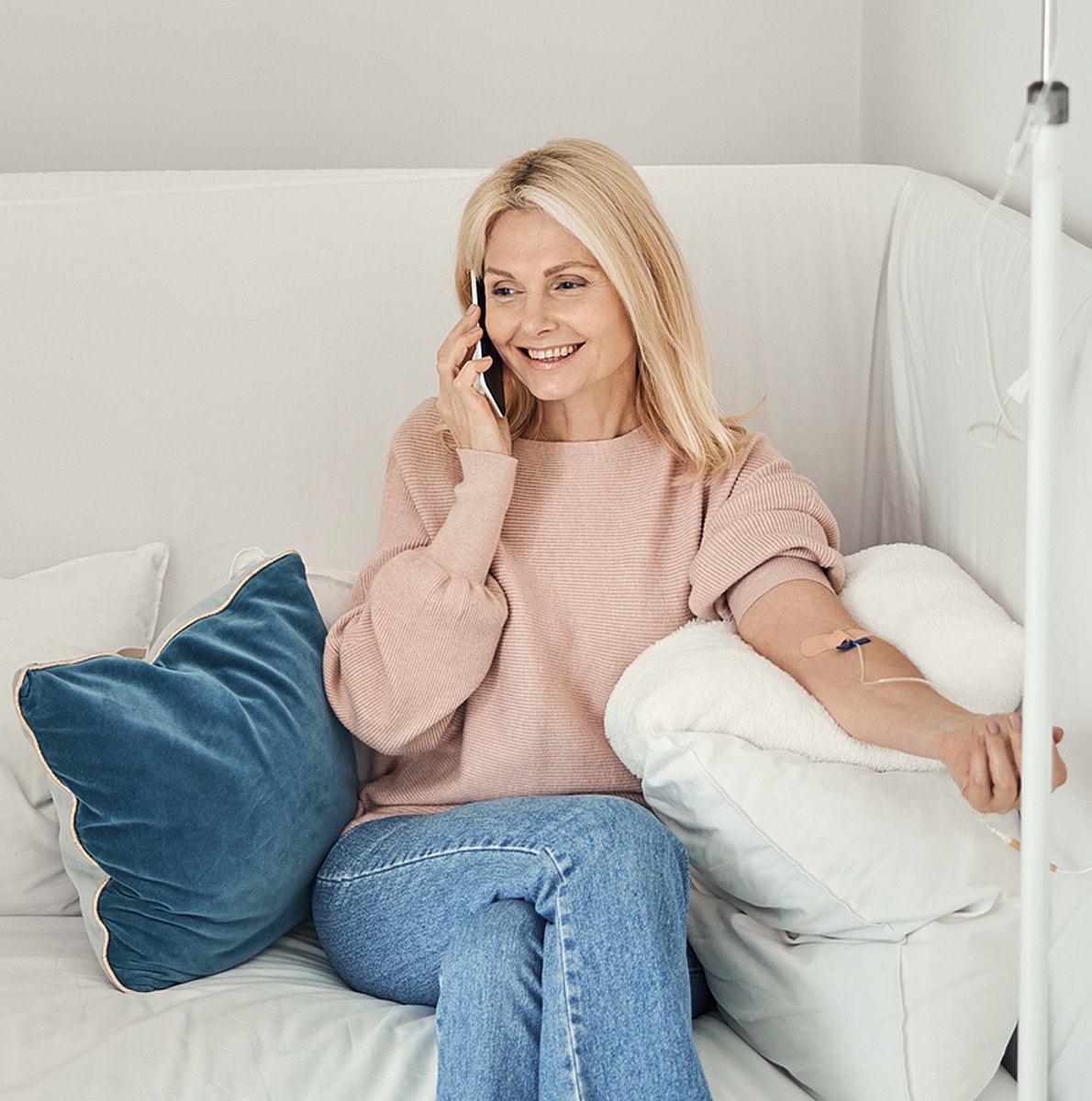 Woman on phone, relaxing at home with IV.