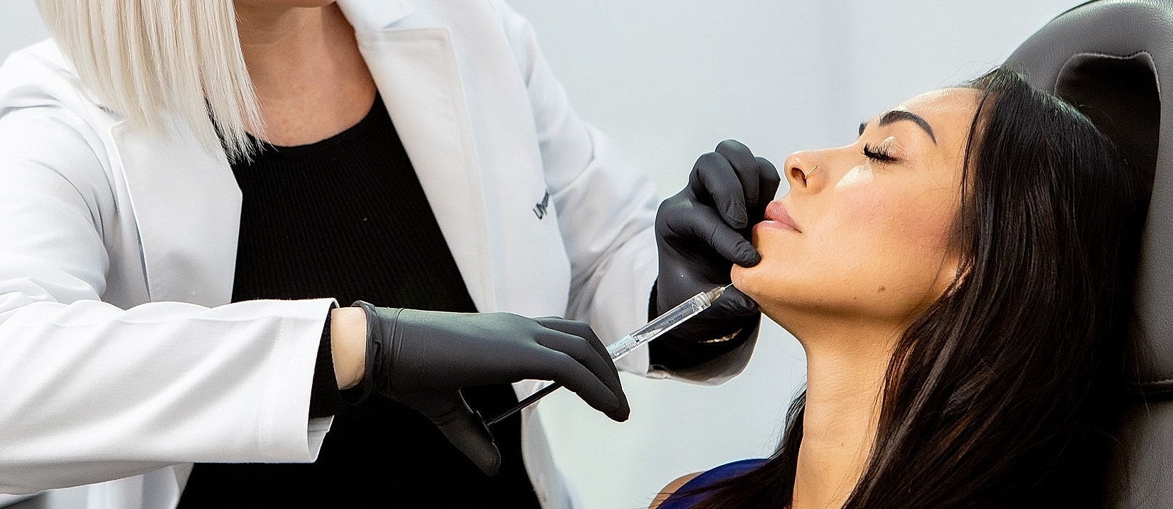 Professional administering Juvederm injection in a clinic setting.