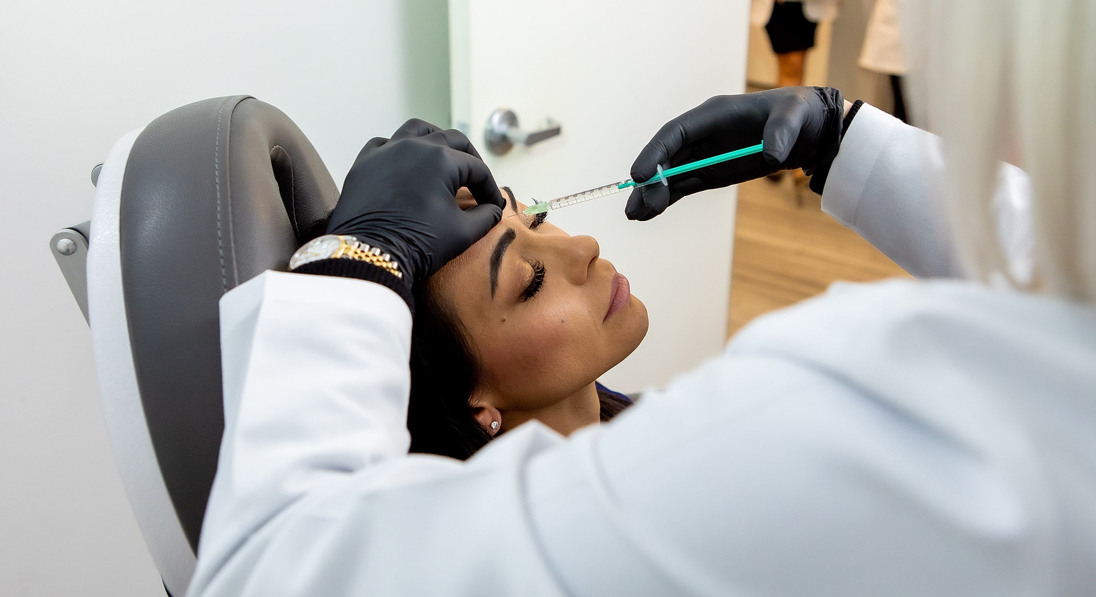 Injecting Kybella treatment in patient’s forehead in Newport Beach & Rancho Santa Margarita..