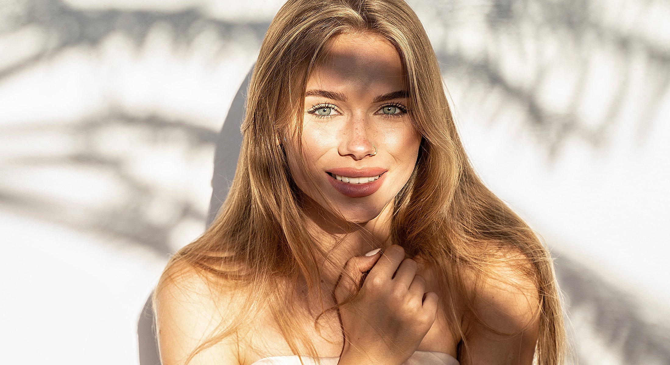Newport Beach & Rancho Santa Margarita Juvederm Ultra Plus XC model smiling with sunlight and shadow effects.